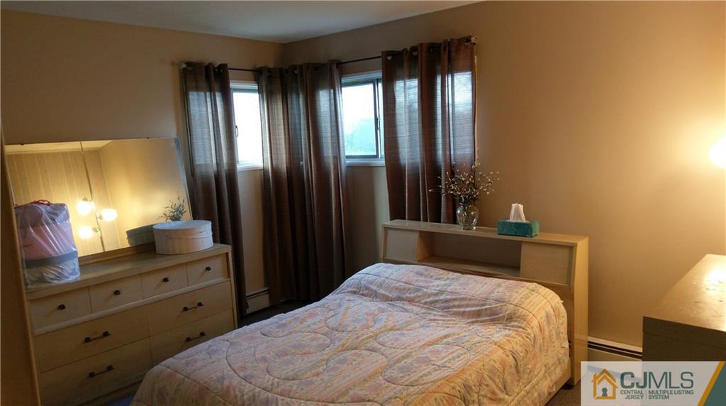 41 Winthrop Road Edison, NJ 08817 - Photo 10 of 18 a bedroom with a bed and a lamp on dresser