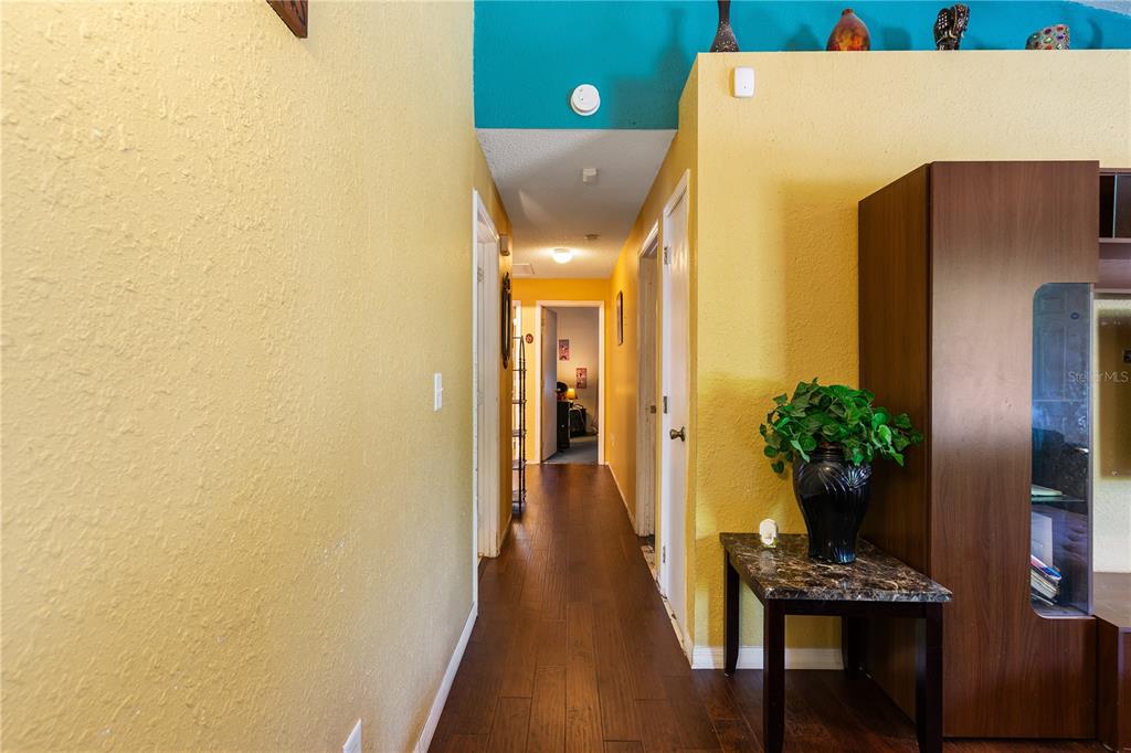 5624 Indialantic Drive Orlando, FL 32808 - Photo 6 of 17 a view of a hallway with wooden floor and a potted plant
