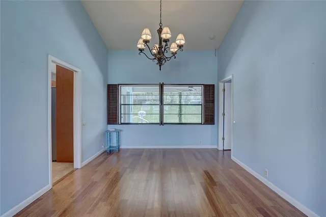 a view of a room with wooden floor and chandelier
