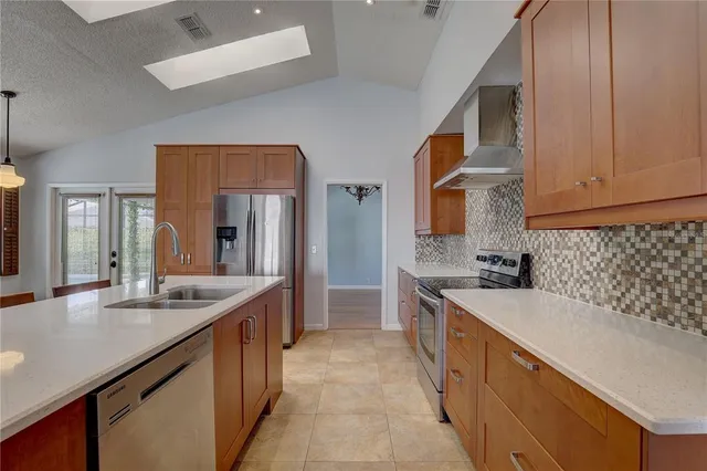 a large kitchen with stainless steel appliances granite countertop a sink and cabinets