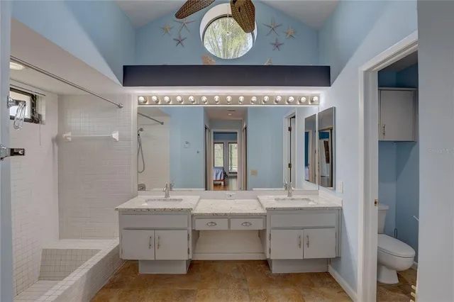 a bathroom with a double vanity sink mirror and bathtub