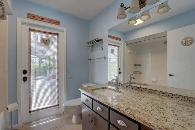 a bathroom with a granite countertop sink a mirror and a bathtub