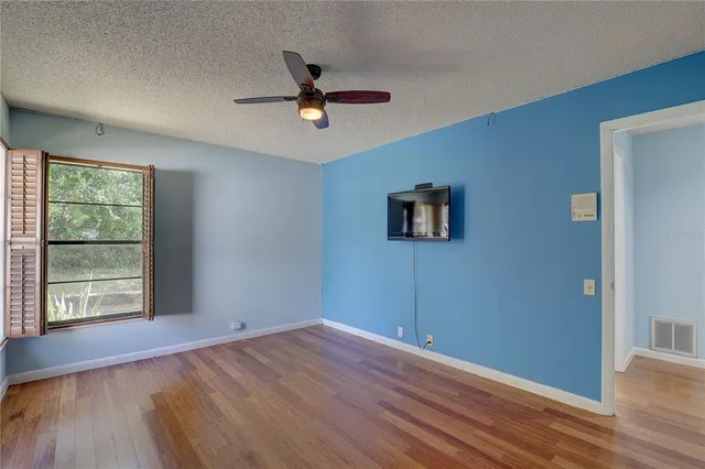 a view of room with wooden floor and ceiling fan
