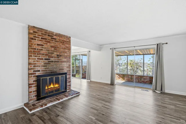a living room with a fireplace and wooden floor