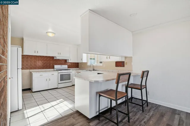 a kitchen with a dining table chairs and a refrigerator