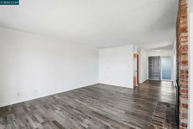 a view of an empty room and wooden floor