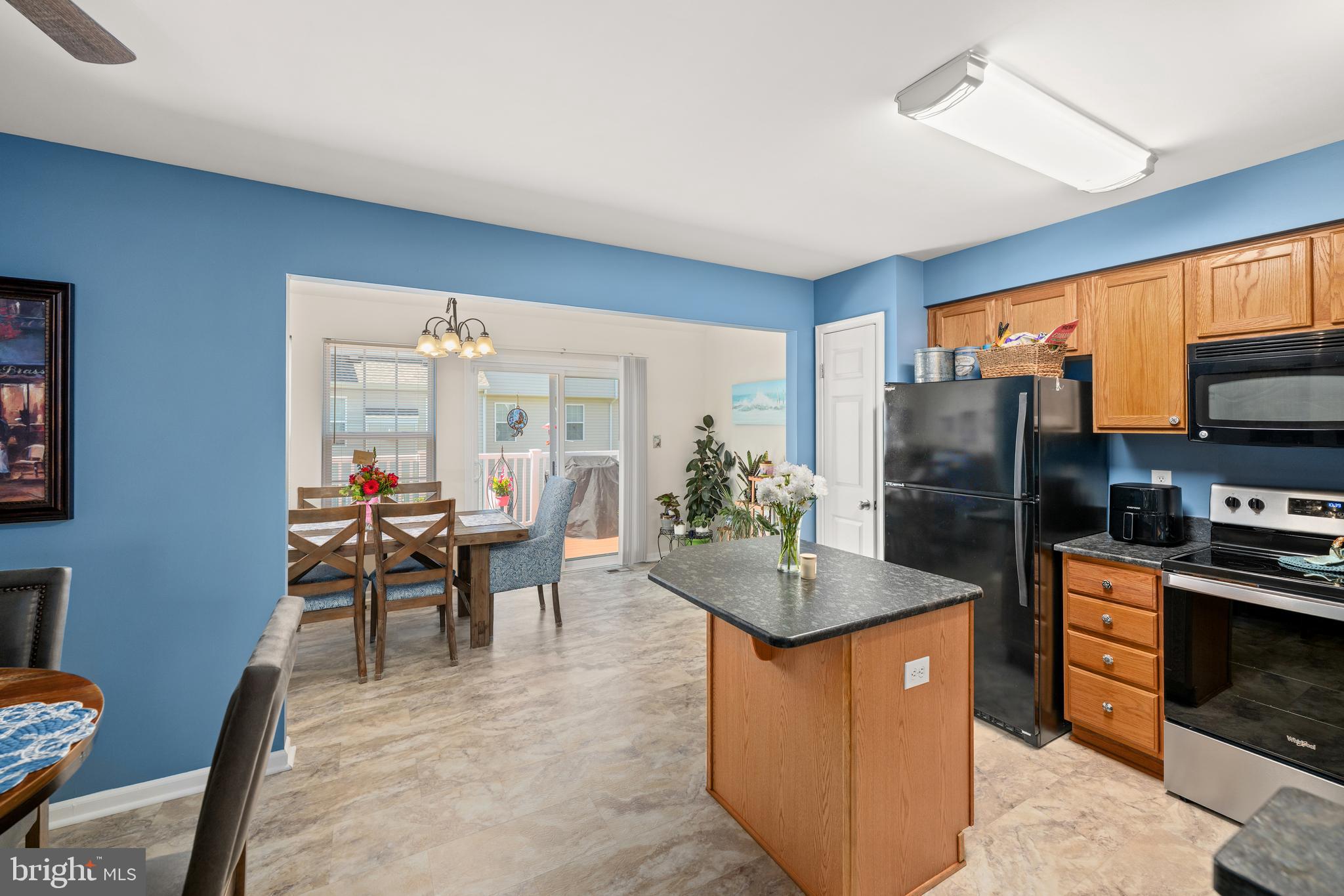 27548 Mayfield Road, Unit 42 Millsboro, DE 19966 - Photo 8 of 46 a kitchen with sink refrigerator dining table and chairs