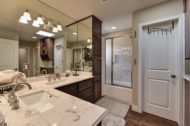 a bathroom with a tub sink mirror and shower