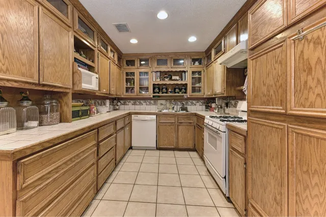 a kitchen with a sink a stove top oven and cabinets