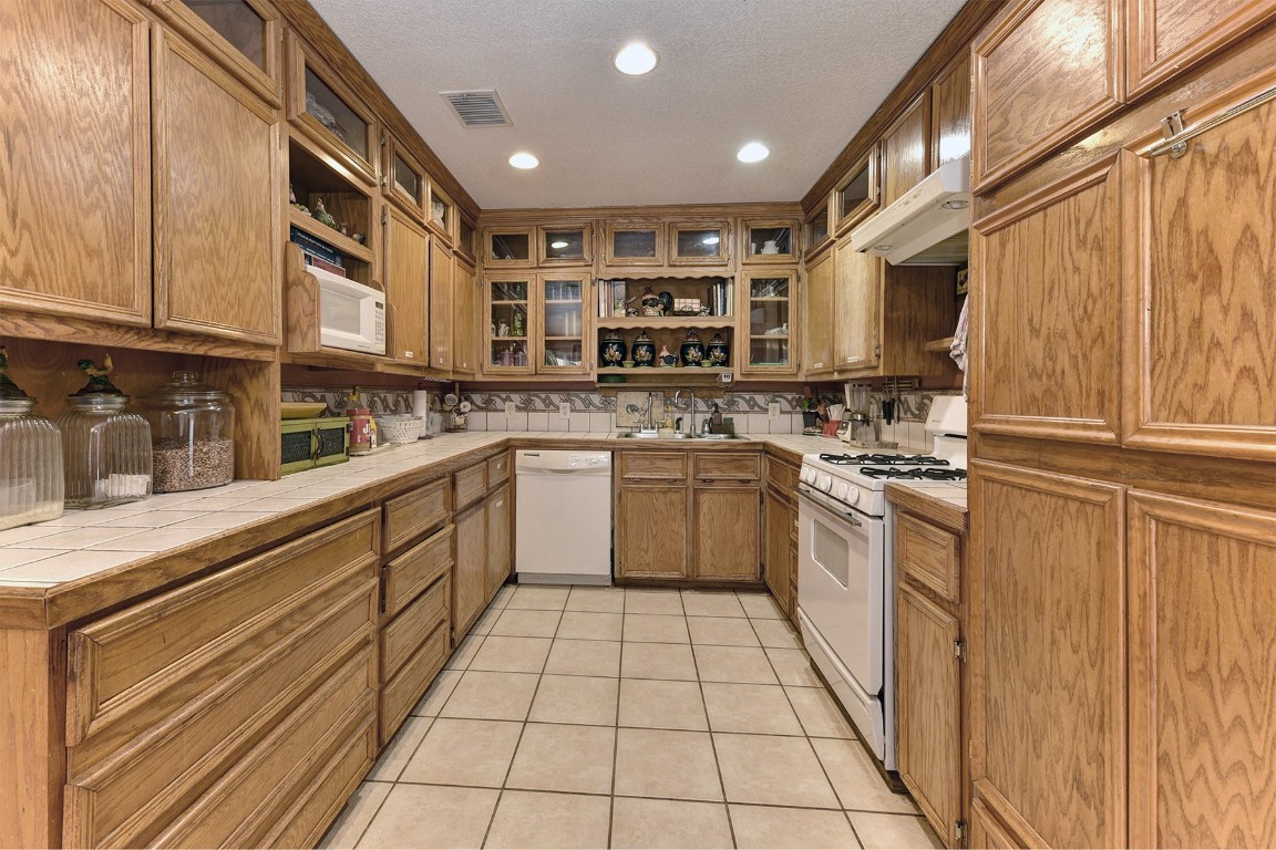 4525 Bell Springs Road Dripping Springs, TX 78620 - Photo 17 of 38 a kitchen with a sink a stove top oven and cabinets