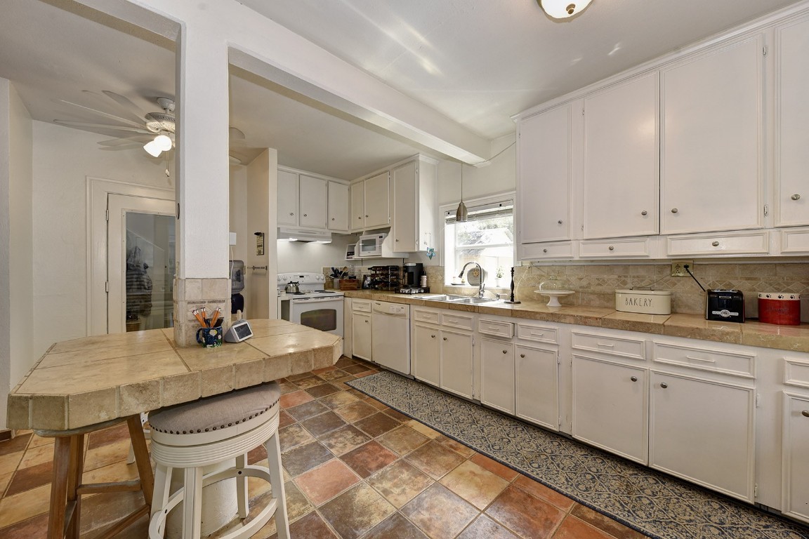 4525 Bell Springs Road Dripping Springs, TX 78620 - Photo 26 of 38 a kitchen with a sink white cabinets and counter space