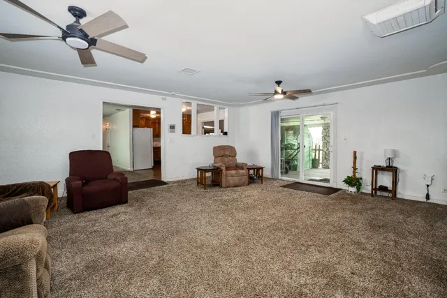 a living room with furniture and a ceiling fan