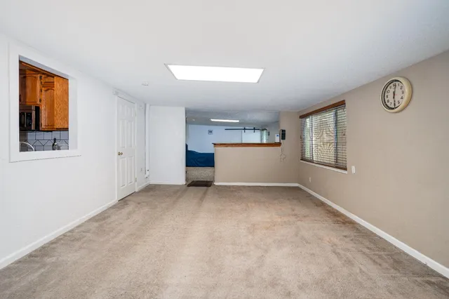 an empty room with windows and cabinet