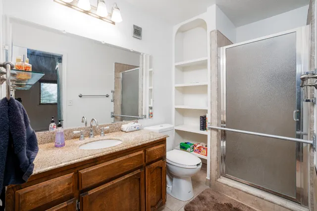 a bathroom with a sink a toilet and shower