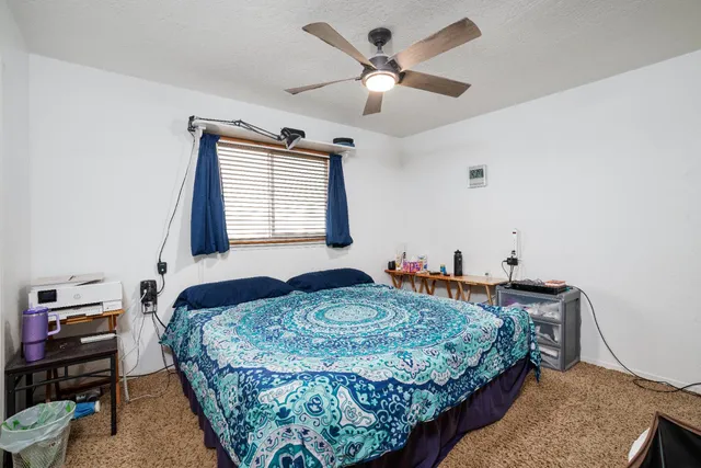 a bedroom with a bed a chandelier and a window