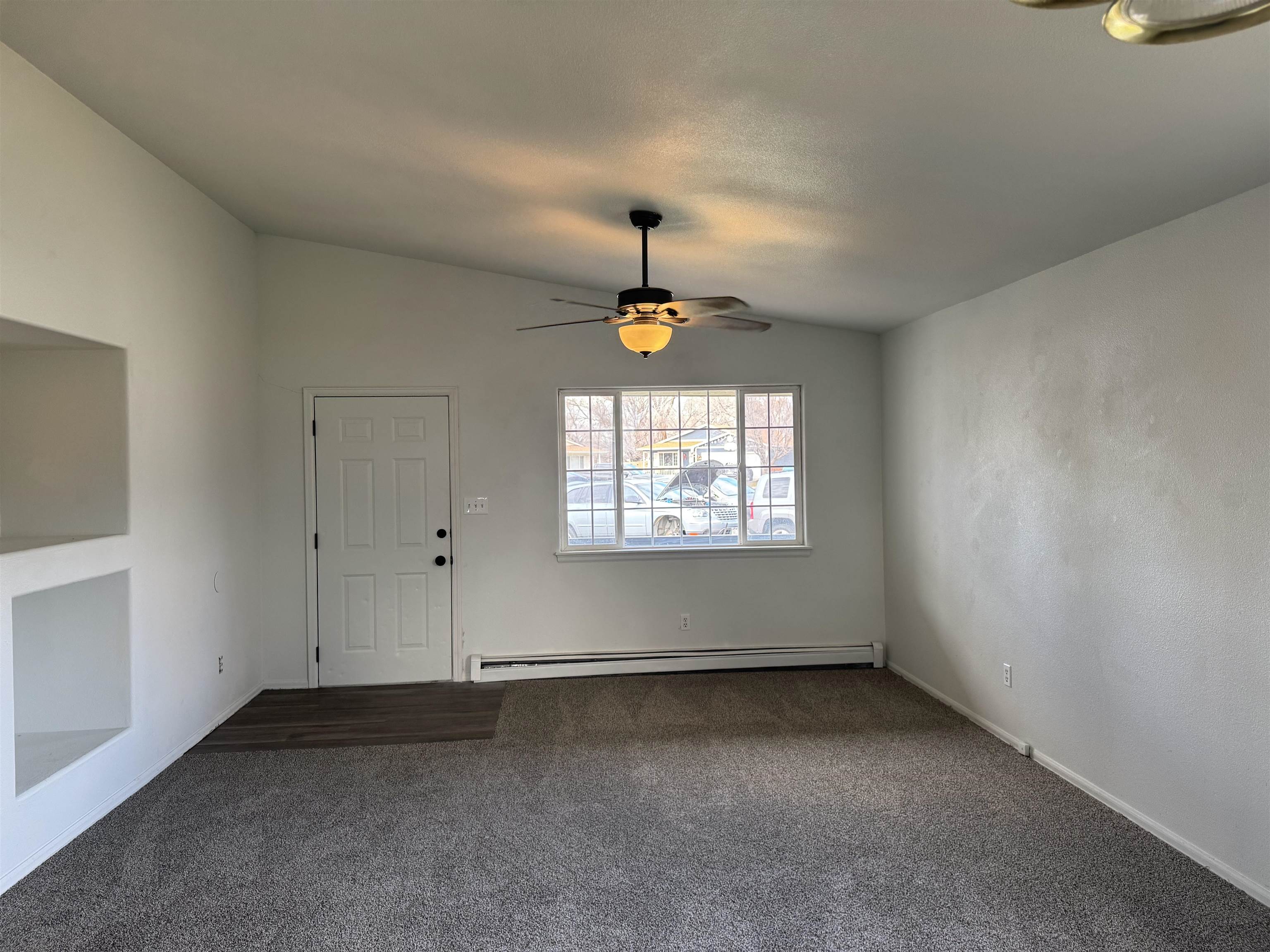 516 Vermont Lane Fruita, CO 81521 - Photo 5 of 13 an empty room with windows and chandelier fan