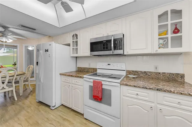 a kitchen with stainless steel appliances granite countertop a stove a sink and a microwave