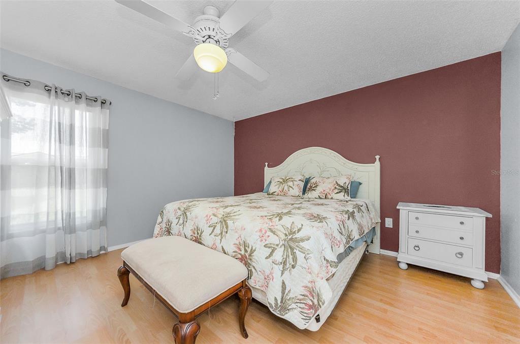 11516 Versailles Lane Port Richey, FL 34668 - Photo 19 of 41 a bedroom with a bed and a chandelier