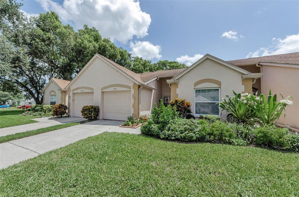 11516 Versailles Lane Port Richey, FL 34668 - Photo 2 of 41 a front view of a house with a yard and garage