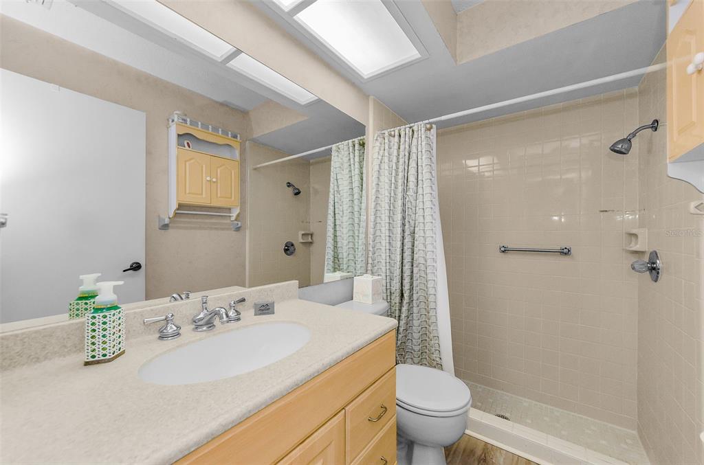 11516 Versailles Lane Port Richey, FL 34668 - Photo 22 of 41 a bathroom with a granite countertop sink a toilet and shower