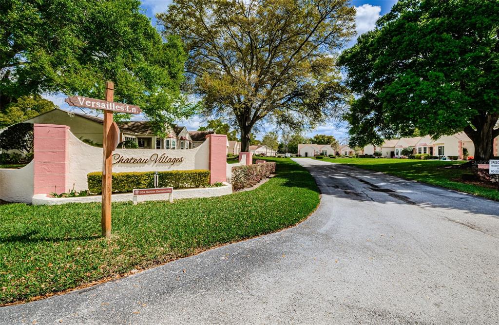 11516 Versailles Lane Port Richey, FL 34668 - Photo 36 of 41 a front view of a house with a yard and trees
