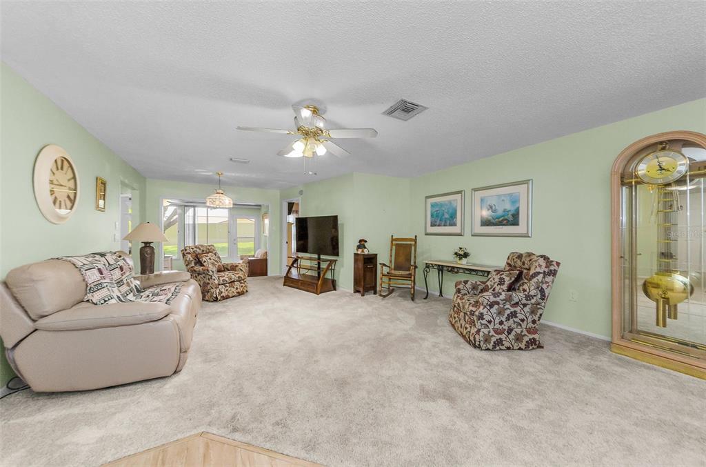11516 Versailles Lane Port Richey, FL 34668 - Photo 7 of 41 a living room with furniture a couch and dresser