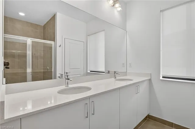 a bathroom with double sink and a mirror