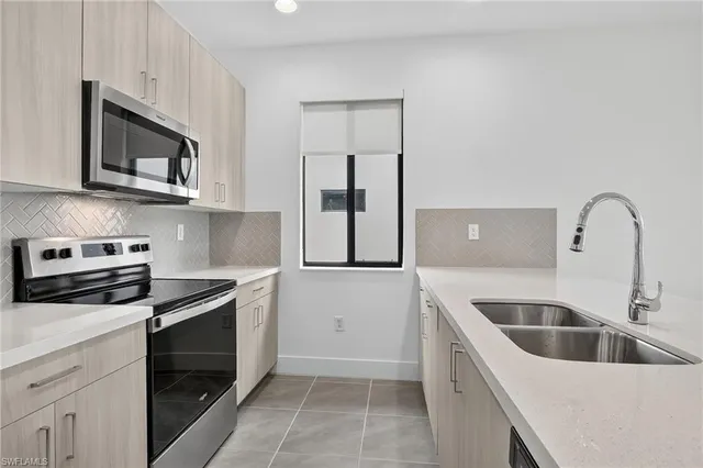 a kitchen with stainless steel appliances granite countertop a sink and a stove top oven with wooden floor