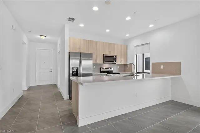 a kitchen with stainless steel appliances a refrigerator sink and microwave