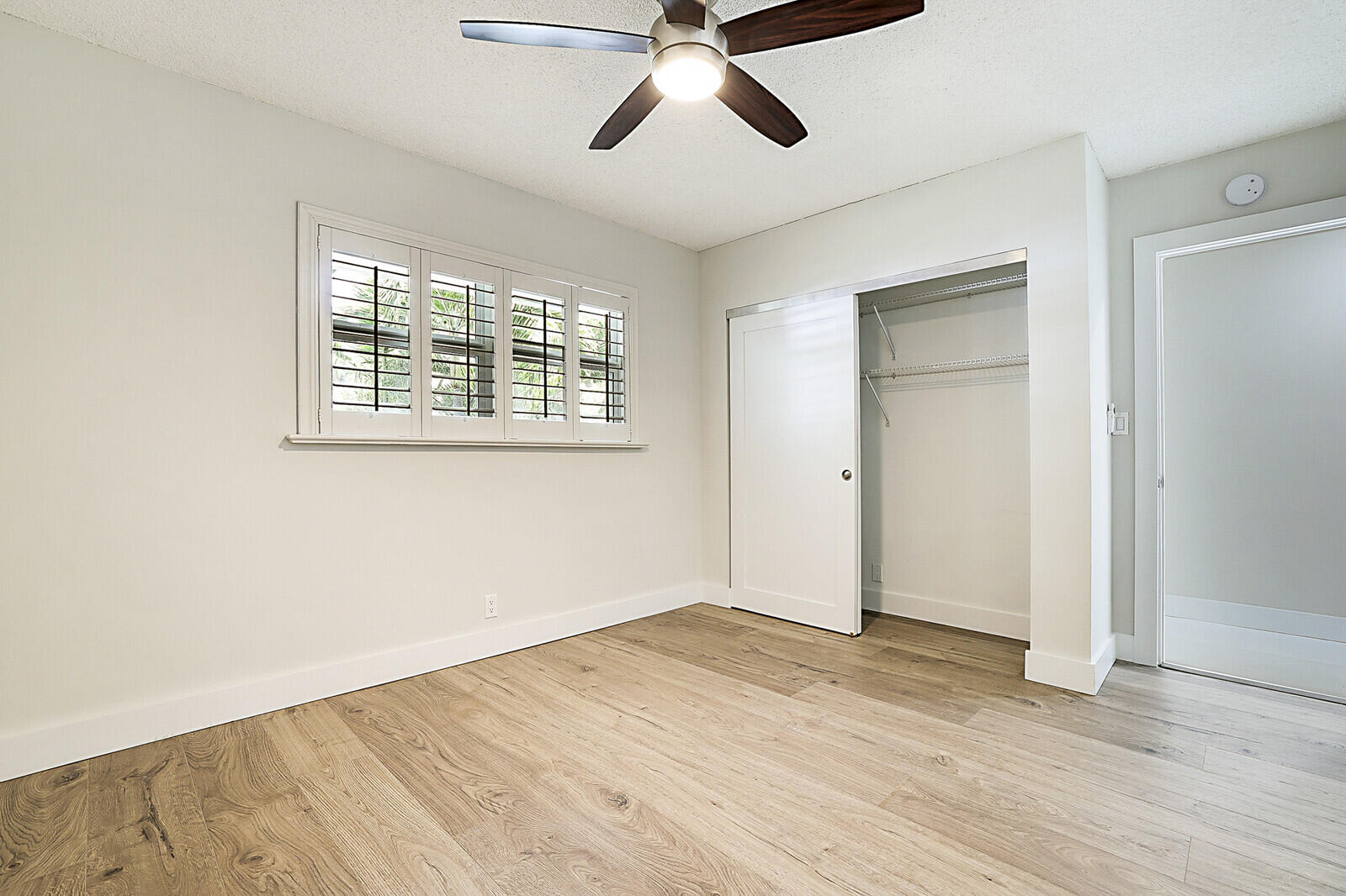 1439 South Ocean Boulevard, Unit 208 Lauderdale-by-the-Sea, FL 33062 - Photo 16 of 27 a view of empty room with wooden floor and fan