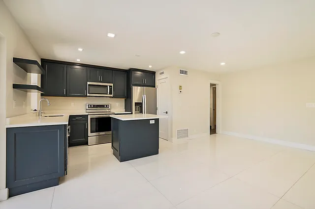 a kitchen with stainless steel appliances a refrigerator and a stove top oven