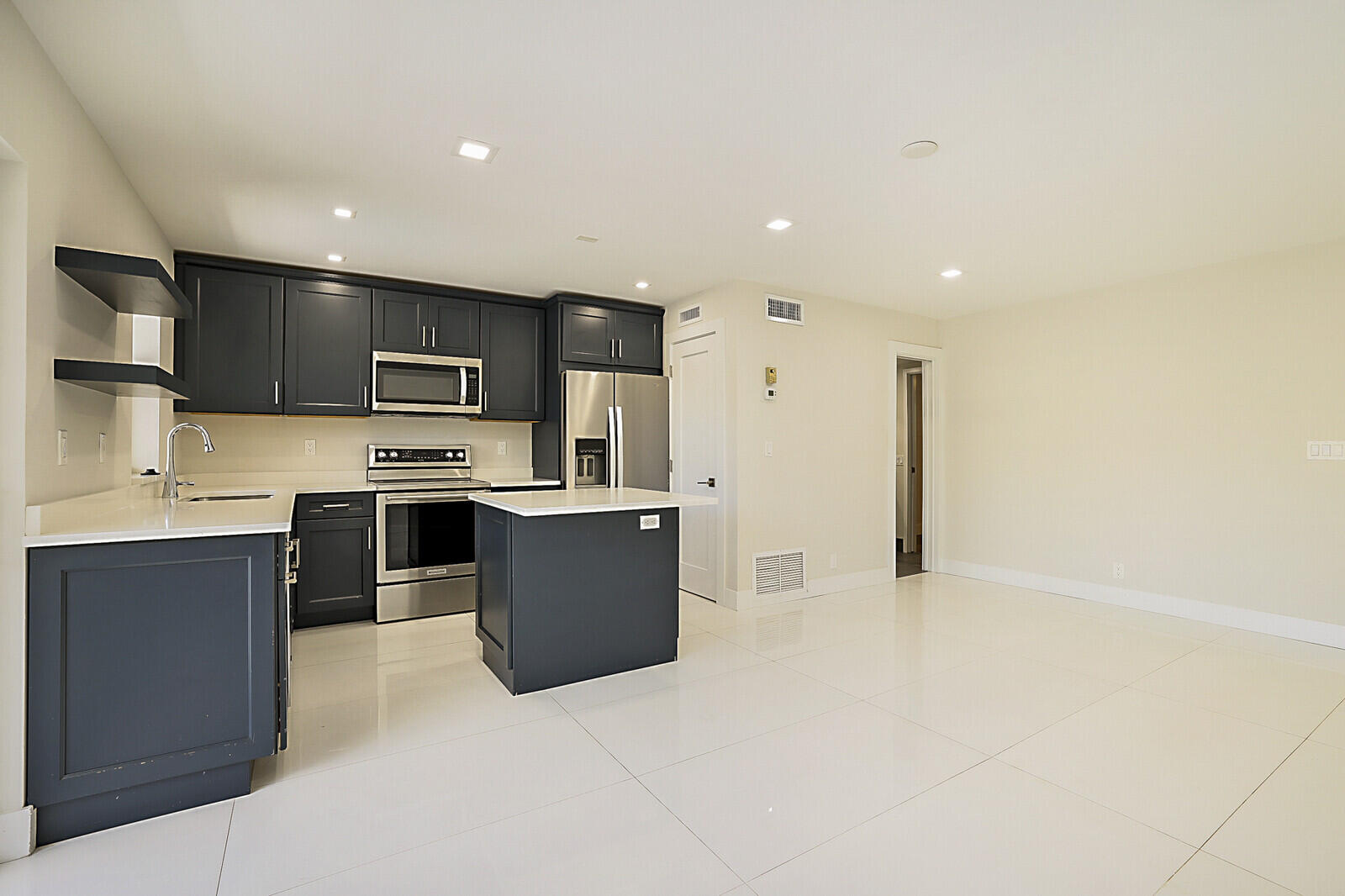 1439 South Ocean Boulevard, Unit 208 Lauderdale-by-the-Sea, FL 33062 - Photo 4 of 27 a kitchen with stainless steel appliances a refrigerator and a stove top oven