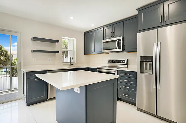 a kitchen with stainless steel appliances a refrigerator and a stove top oven