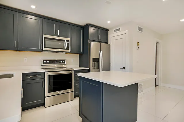 a kitchen with stainless steel appliances a stove microwave and refrigerator