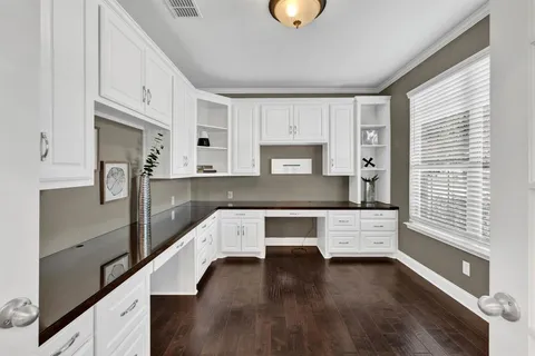 a kitchen with stainless steel appliances cabinets and a wooden floor