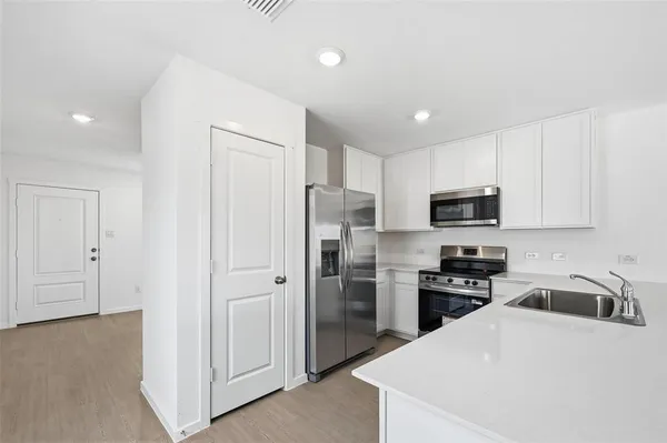 a kitchen with stainless steel appliances granite countertop a refrigerator sink and stove