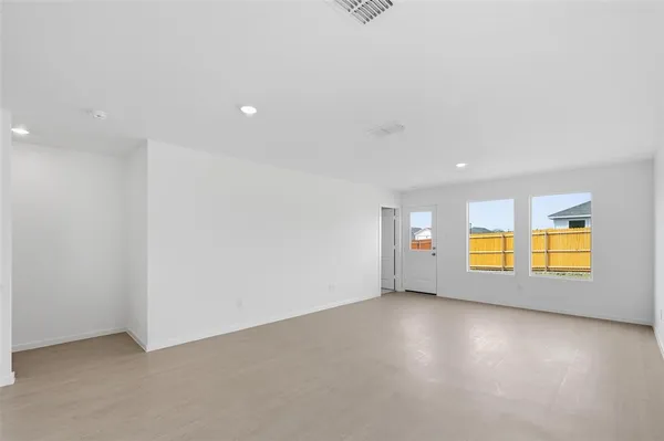 an empty room with a window and wooden floor