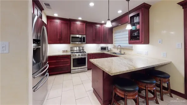a kitchen with kitchen island granite countertop a sink cabinets and stainless steel appliances