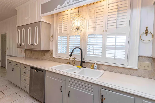 a sink with a window and cabinets