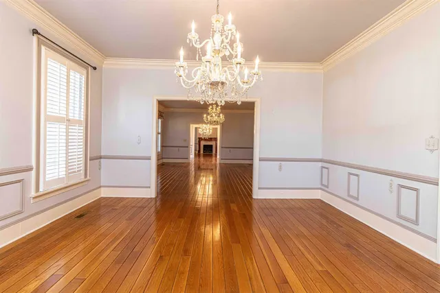 a view of empty room with wooden floor and large window