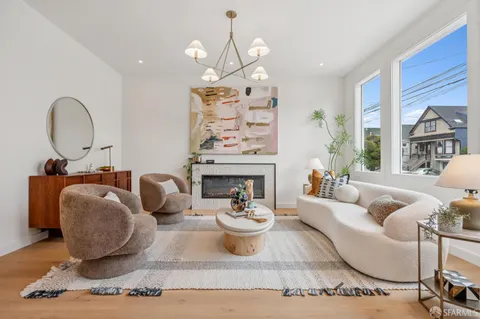 a living room with furniture a fireplace and a chandelier