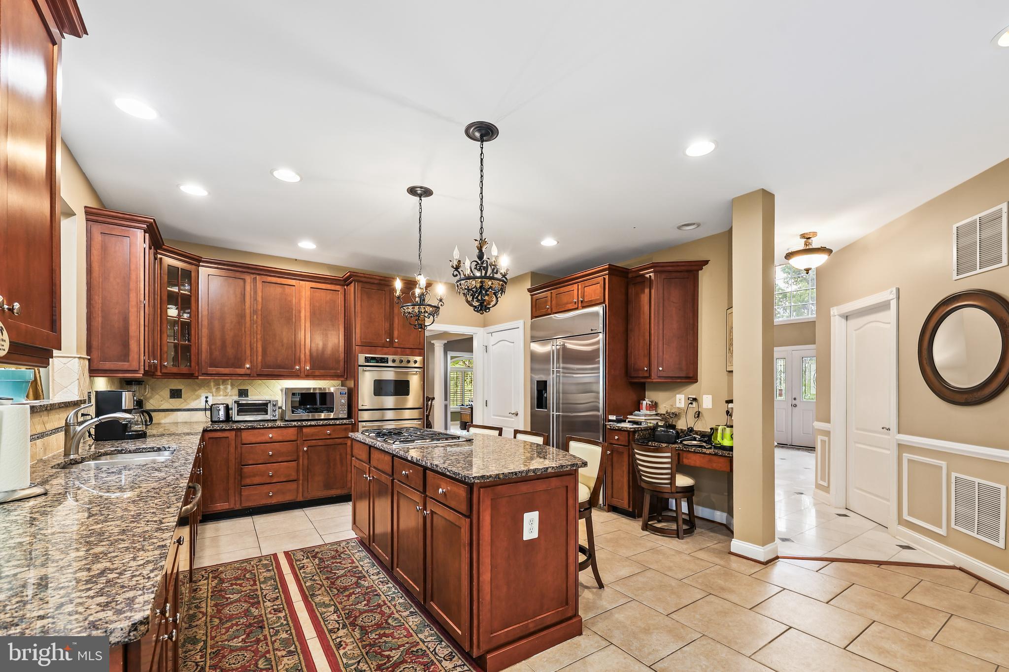 40890 Beechnut Road Leesburg, VA 20175 - Photo 19 of 65 a kitchen with stainless steel appliances granite countertop a stove a sink dishwasher and a refrigerator with wooden floor