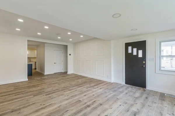 a view of a kitchen with wooden floor and a refrigerator