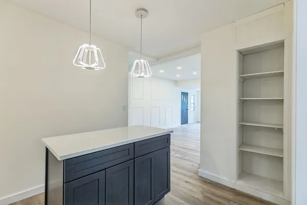 an empty room with wooden floor closet and windows