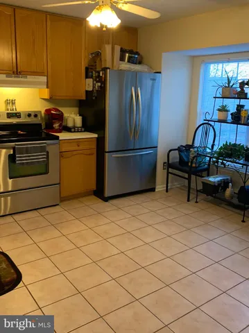 a kitchen with a refrigerator and a stove top oven