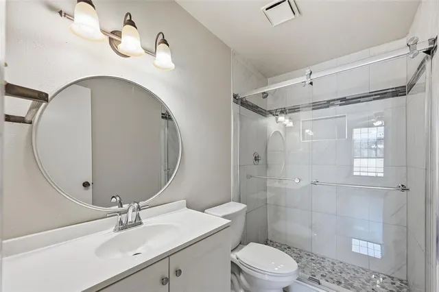 a bathroom with a sink a toilet and shower