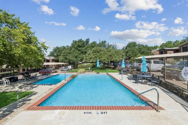 a view of a swimming pool with a patio and a yard