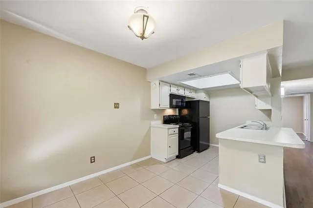 a view of a kitchen with refrigerator and white cabinets