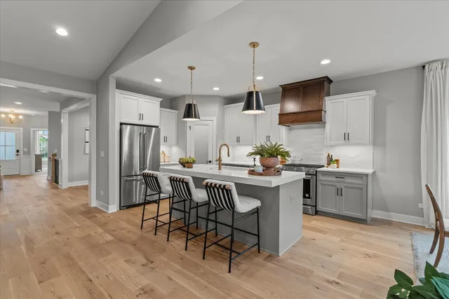 a kitchen with stainless steel appliances kitchen island granite countertop a sink and a refrigerator
