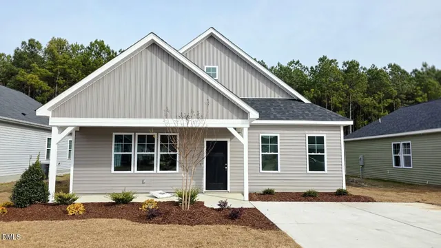 a front view of a house with a yard outdoor seating and garage